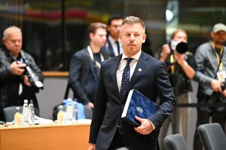 Hungarian official carrying documents at an EU council meeting