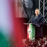 Hungarian Prime Minister Peter Magyar speaking at a 1956 uprising commemoration podium