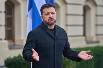 Ukrainian President Volodymyr Zelenskyy gesturing while speaking outdoors
